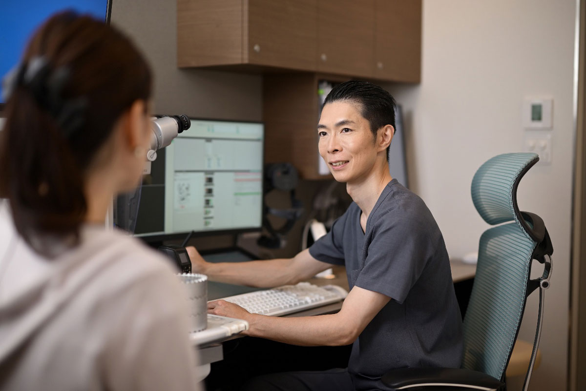 笑顔で患者様の診察をおこなう医師